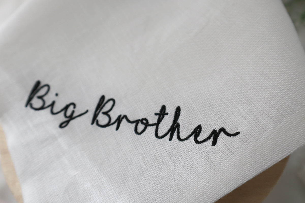White fabric with 'Big Brother' embroidered in black