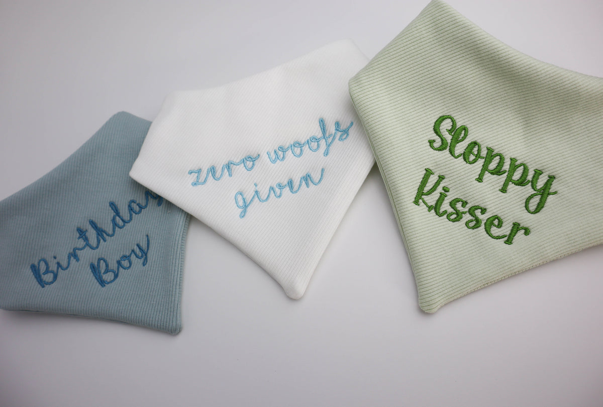 Three embroidered socks with humorous text on a light background