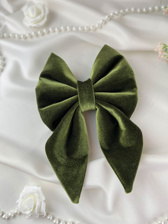 Green velvet bow on a white fabric background