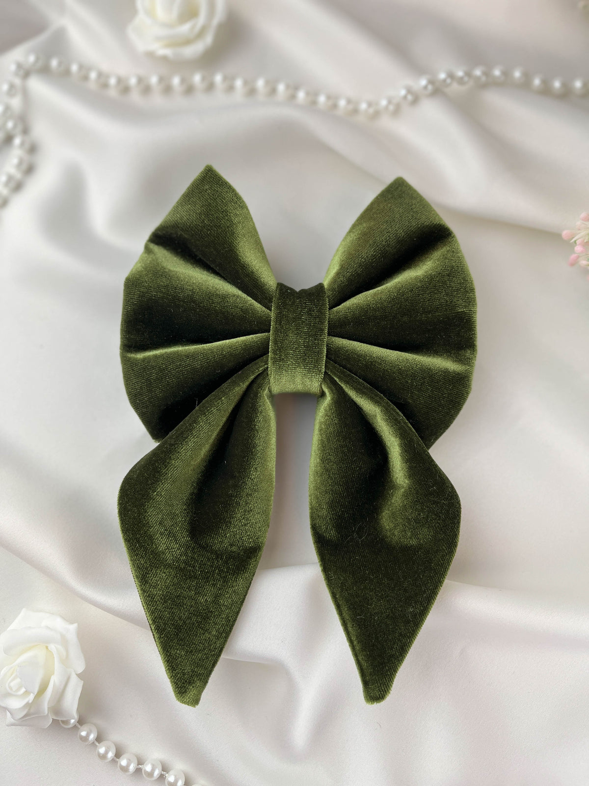 Green bow on a white fabric background