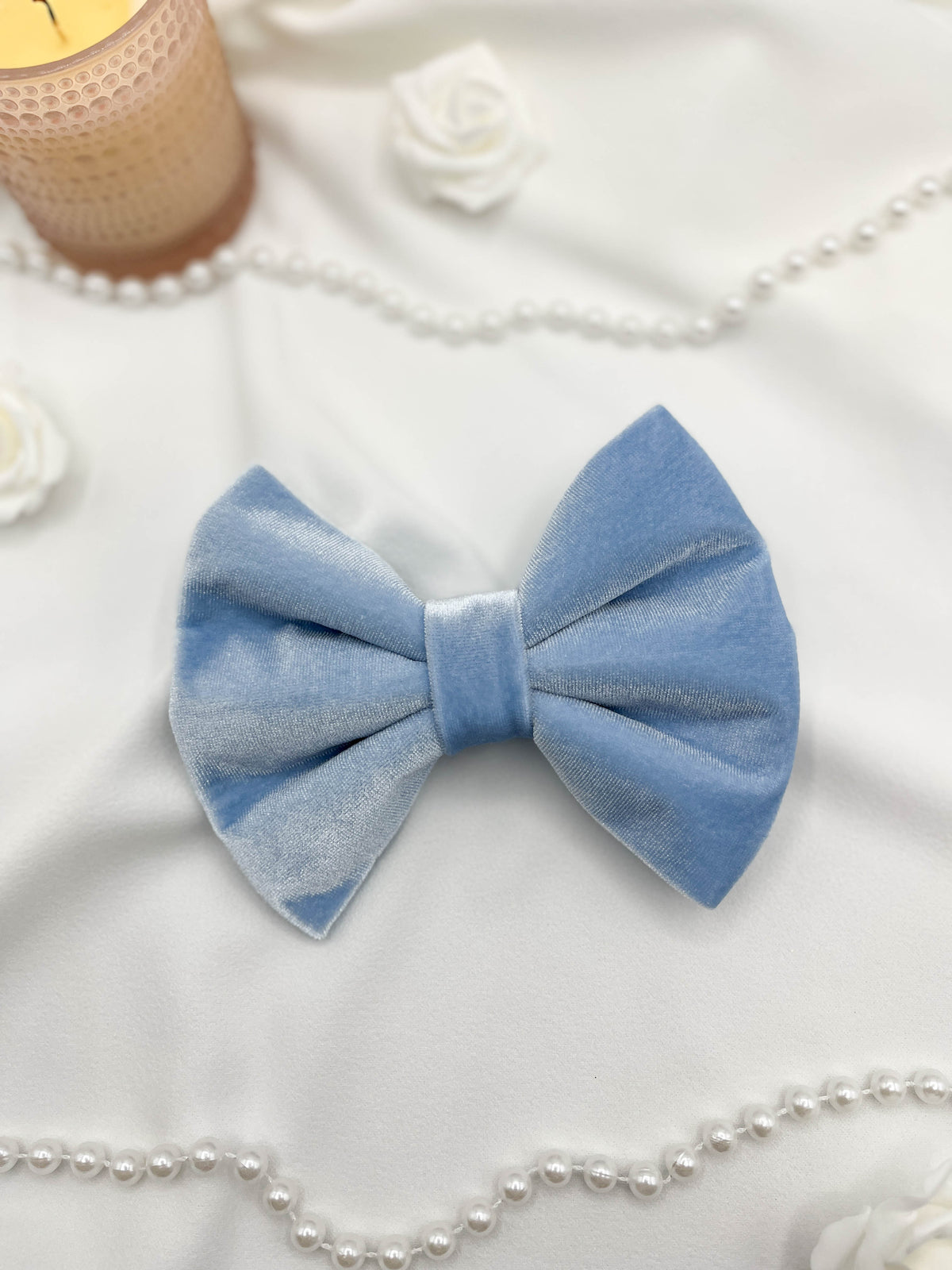 Blue bow tie on a white surface with decorative elements