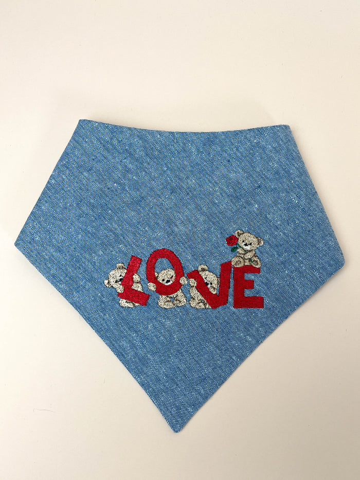Blue bandana with 'LOVE' and teddy bear designs on a beige background