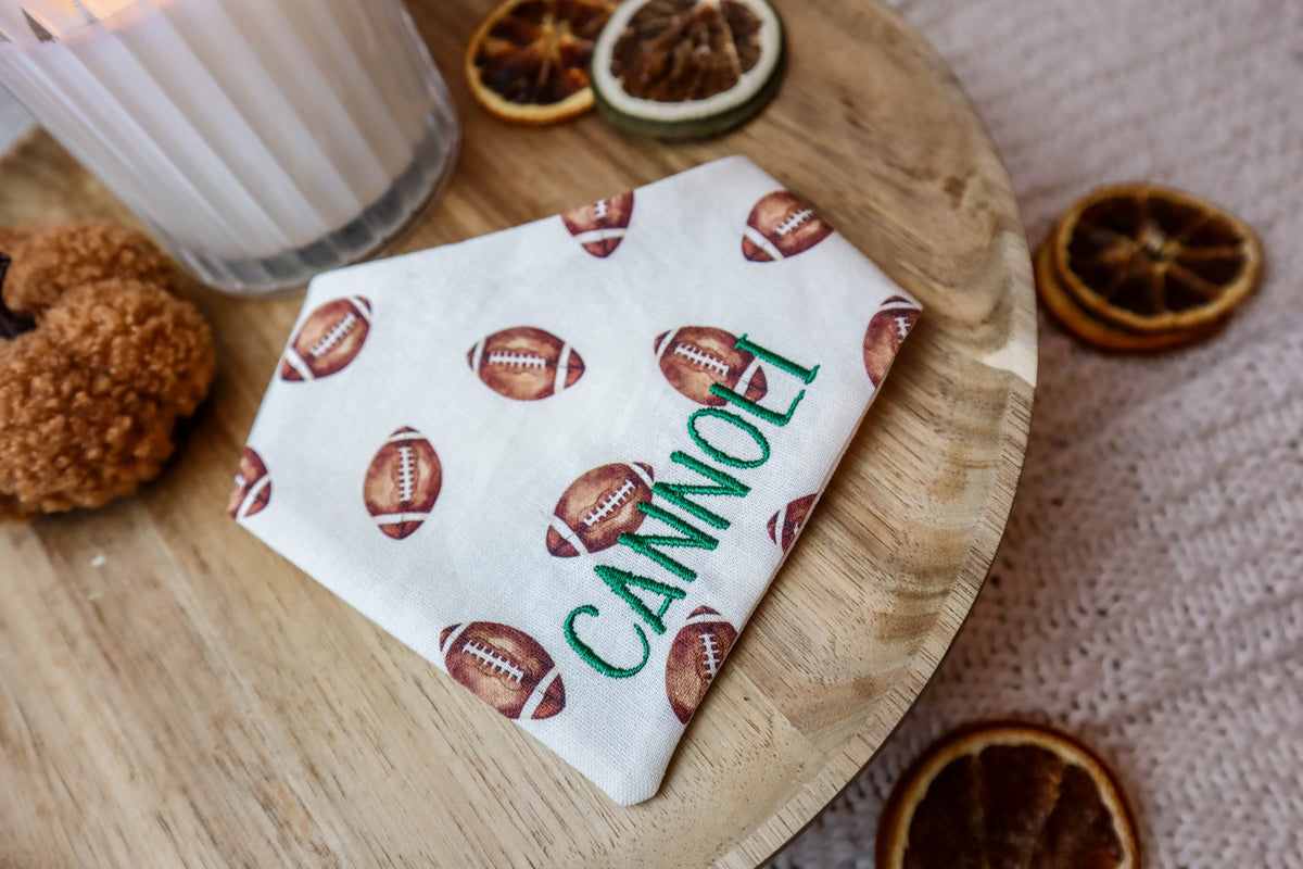 bandana with football pattern and 'Cannoli' text on a wooden board with dried oranges.