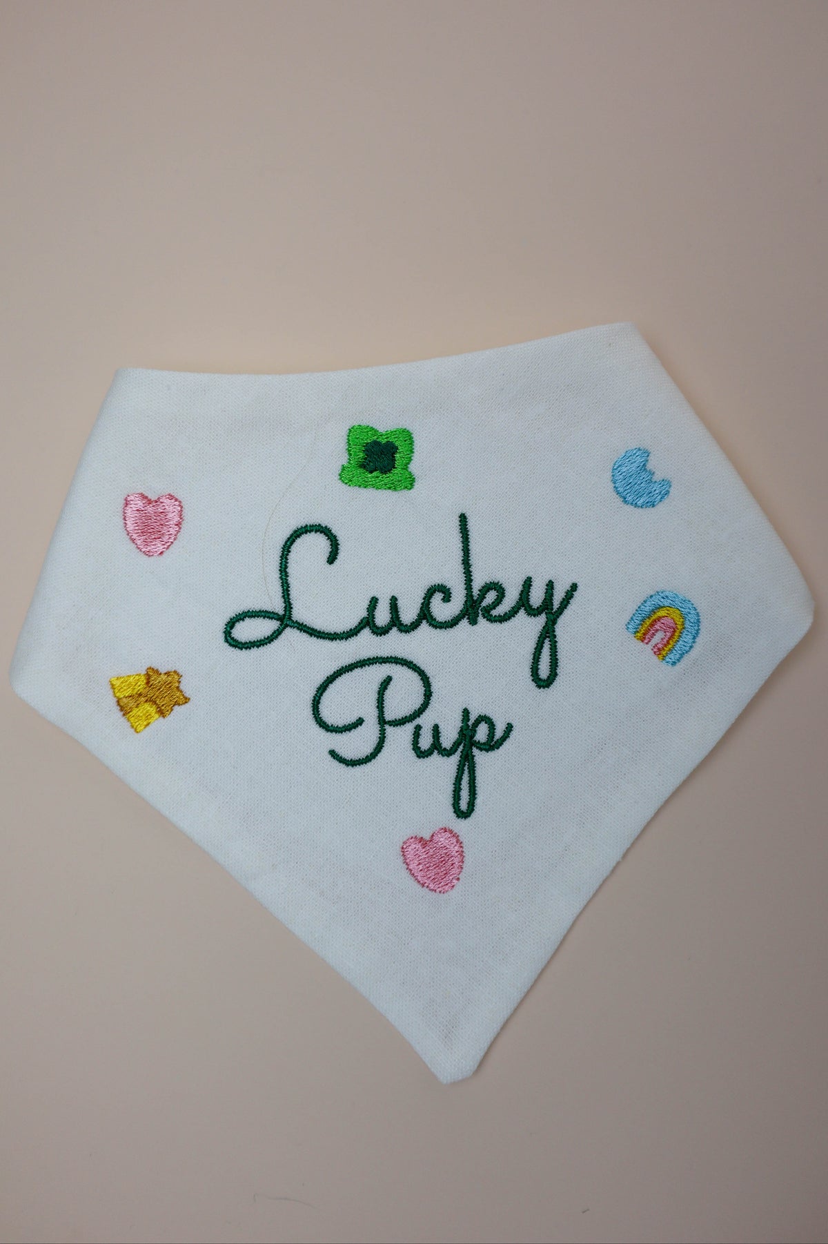 White bandana with 'Lucky Pup' embroidery on a beige background