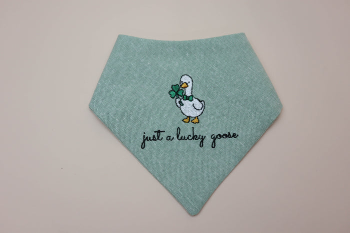 Green bandana with a goose design and text on a beige background