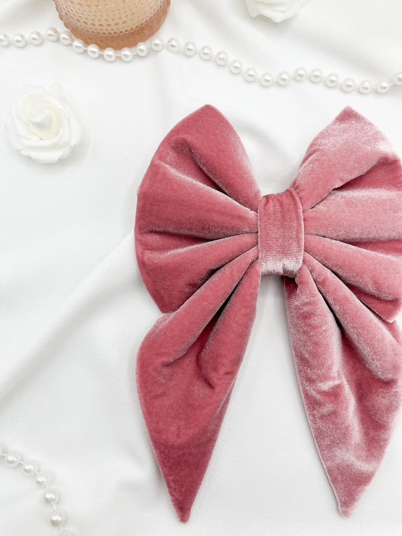 Pink velvet bow with pearls and flowers on a white background